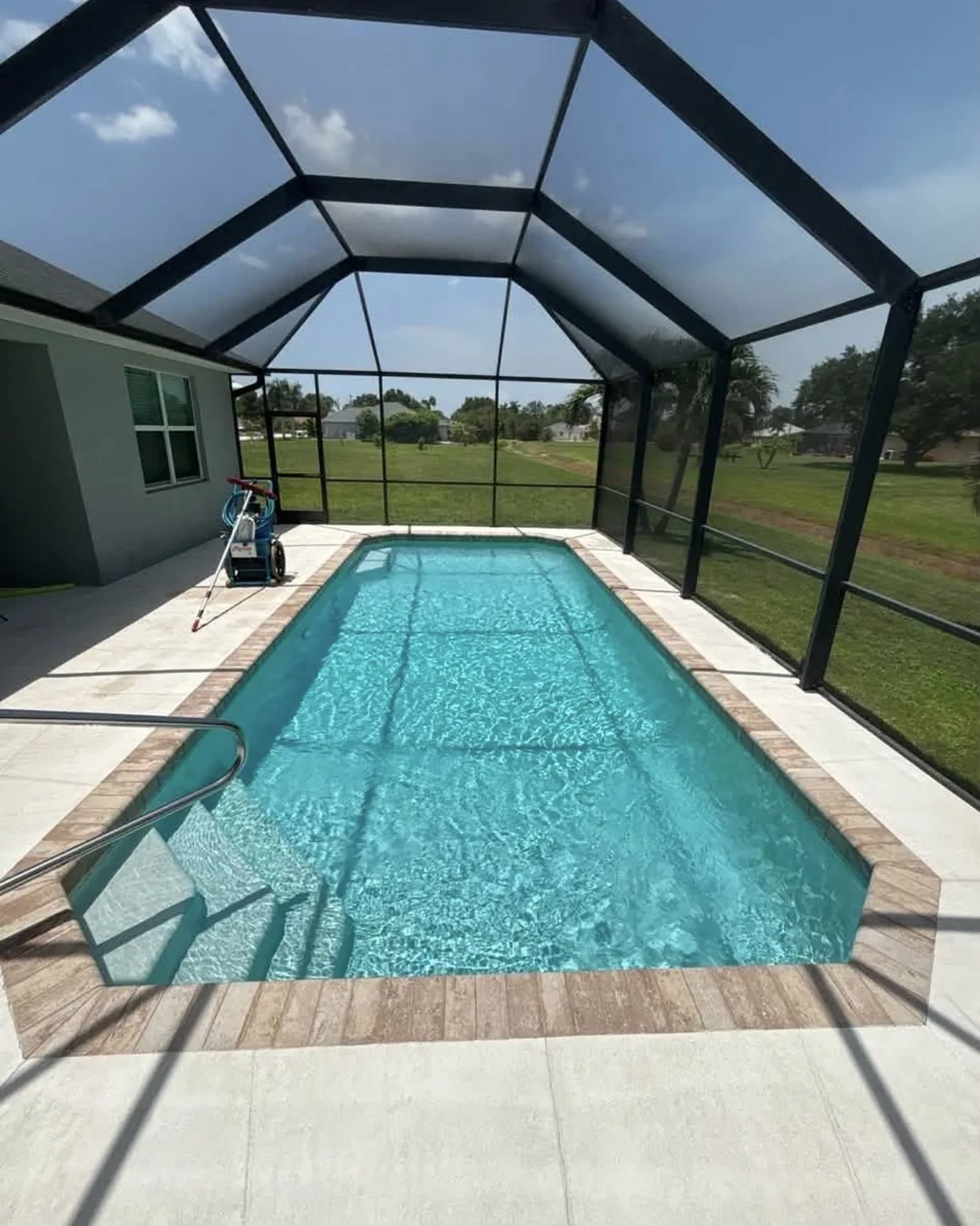 Bright blue residential pool with a screened patio